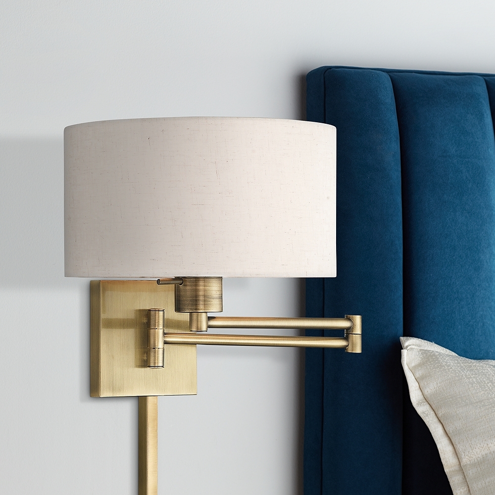 Antique Brass Swing Arm Wall Lamp with Oatmeal Drum Shade - Image 1
